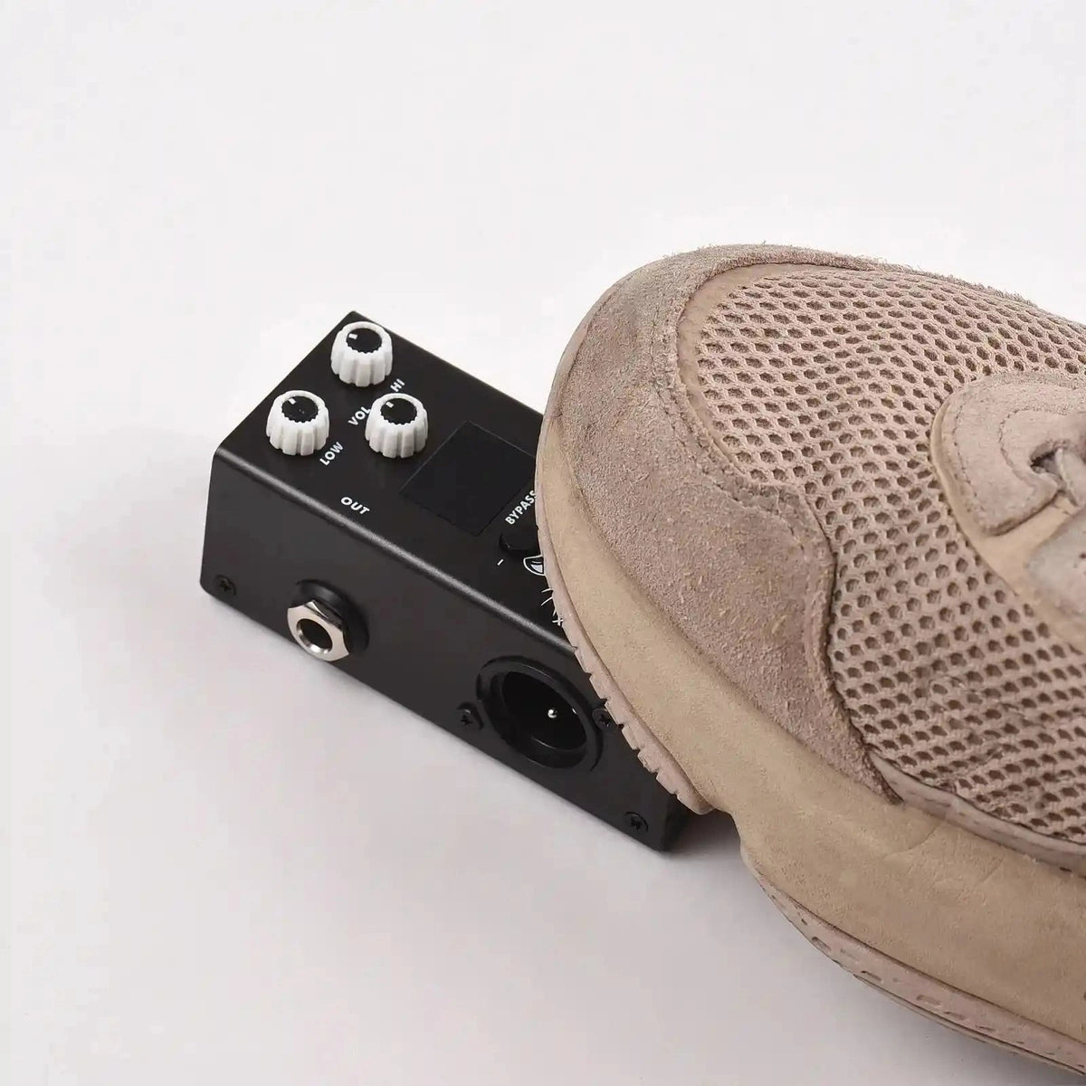 M-VAVE IR Box guitar pedal being pressed by a sneaker, showcasing its durable design and XLR output port for high-quality impulse response simulation.